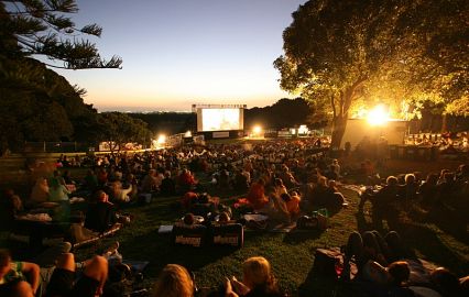 Magical evening at Tyvipuu Open-Air Cinema with movie projected against night sky